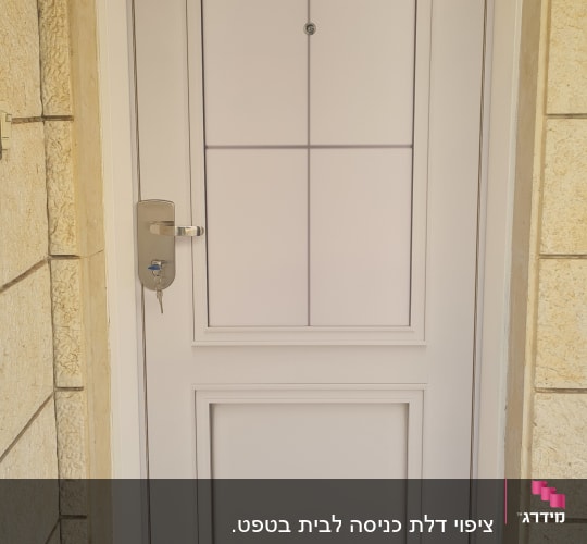 דלת לבנה עם ידית מתכת ומנעול